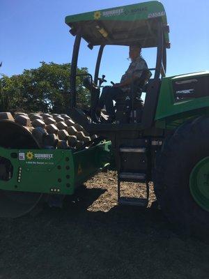 Compacting soil for the plot before we can start foundation trenching.