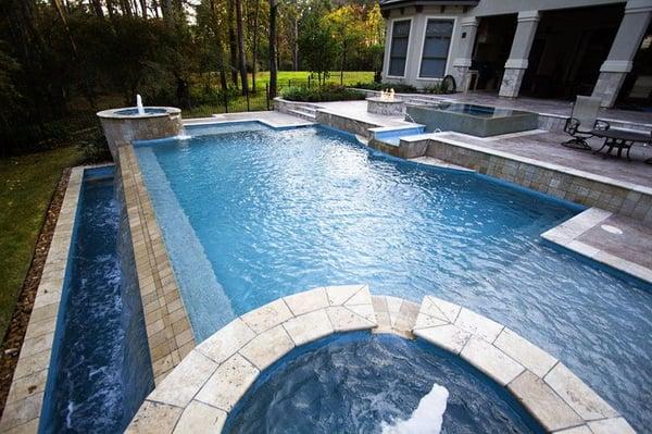 Multilevel pool with perimeter overflow spa and negative edge pool.