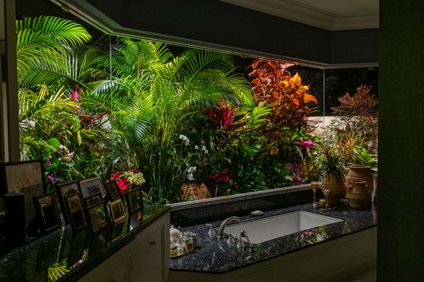 This luxury bath setting includes the perfectly illuminated gardens to create a tranquil spa atmosphere for this estate home in Palm Beach.