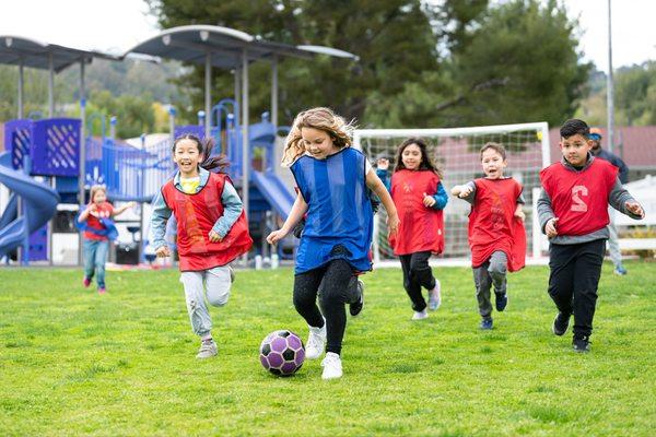 Students playing soccer on the field.