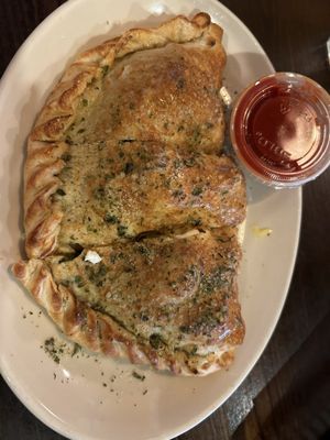 Calzone with chicken, spinach, feta and mozzarella cheese.