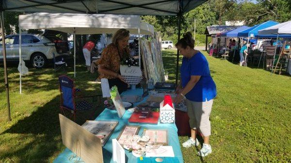 A local school teacher sets up a booth to sell her art.