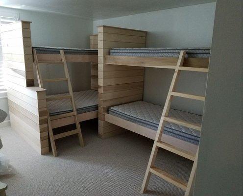 2 sets of custom built bunk beds with shiplap siding. One set is a twin over full, the other is a twin over twin.