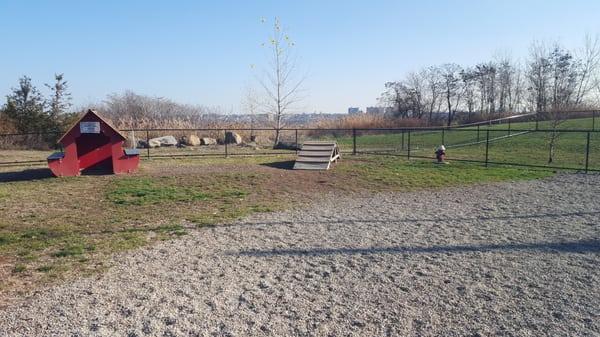 Park has two fenced-in areas, one mostly grass and one mostly pebbles, with a ramp, tunnel & dog house.