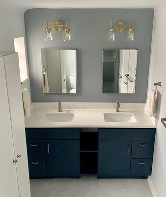 Complete Bathroom remodel: 2 x 30" cabinets joined with custom shelves, quartz counter, and prominent gold fixtures