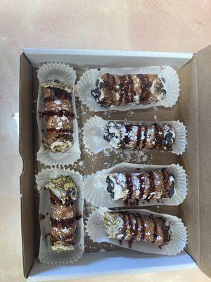 Cannolis with chocolate chips, pistachios, and chocolate drizzle