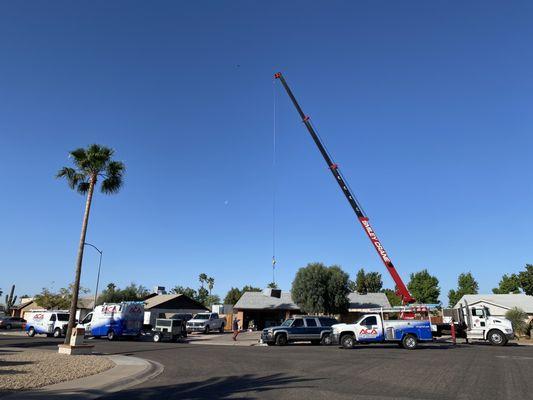 Crane removing old unit and loading new equipment