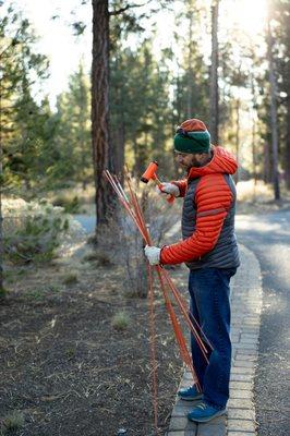 placing snow stakes in preparation for wintertime snow removal