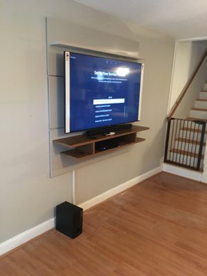 Manhattan Comfort TV floating Tv wall and mounting installation, with sound bar and sub woofer.