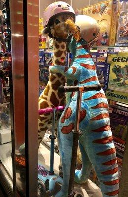 Such a cute window display, a T-Rex and a giraffe hugging.