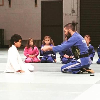 Presenting a belt promotion in Brazilian Jiu Jitsu to a member of the kids / youth program at P5 Academy in San Diego, Ca.