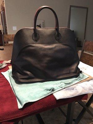 I had give it a total of 3 coats. The bag was originally a rose color so dying it black, in some spots it looked more purple.