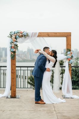 Modern wood beam arch, silk florals and drapery.