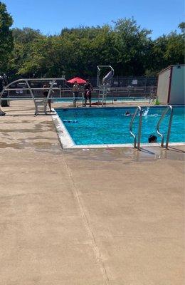 Adult pool with diving board and life guard