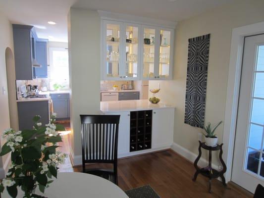 Blue shaker cabinets,  white cabinets where a previous wall had been, make both rooms light and bright.