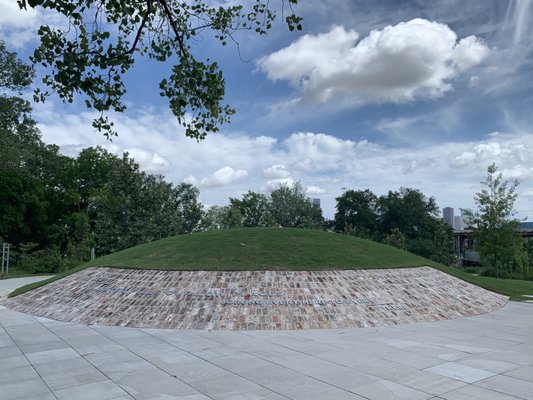 Hill overlooking the city of Houston, with sign that reads: "See water fills our lowest places joining every here to every there"