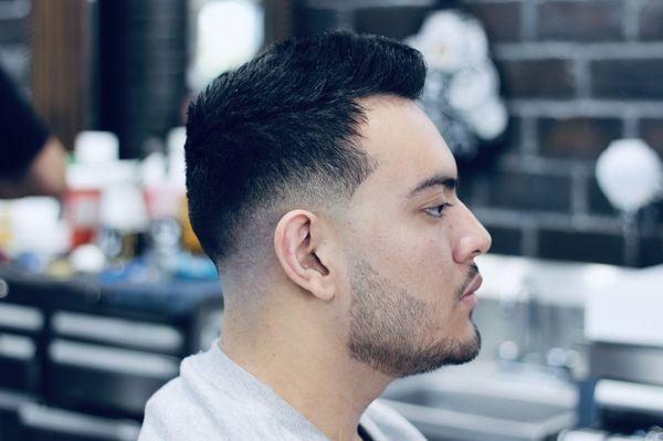 Low drop fade, with texture up top, and a beard trim and shave.