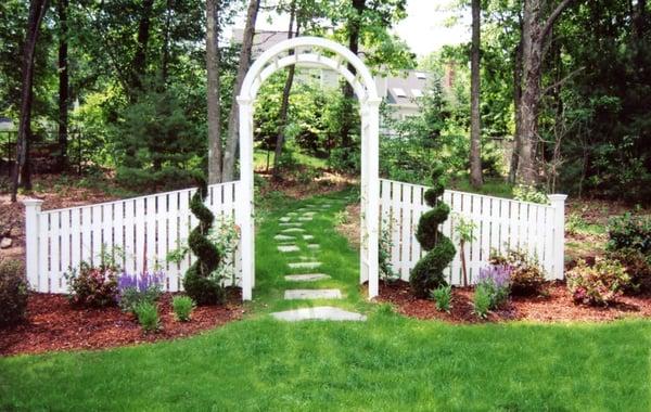 Arbor fence with landscaping surrounding area.