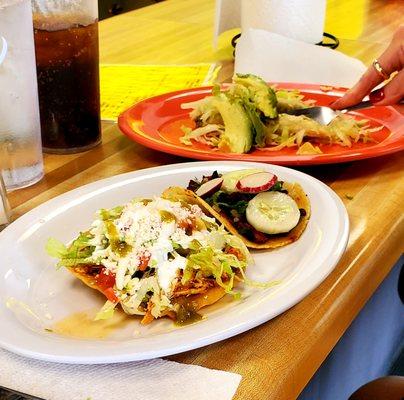 Chicken tostadas, carnitas taco, and tamale with lettuce and avocado added for a little extra $