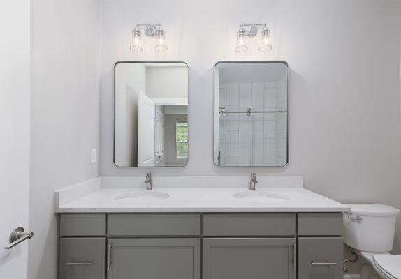 Double vanity with white quartz countertops.