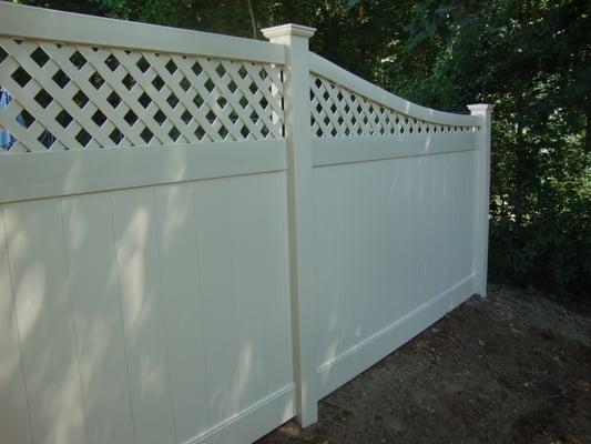 Almond vinyl diamond lattice top fence with curved top rail.