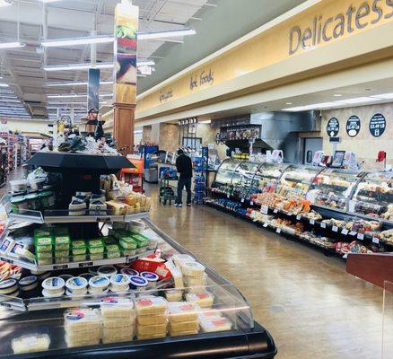 A deli counter with all kinds of meats and cheeses. Conveniently located right after the veggies.