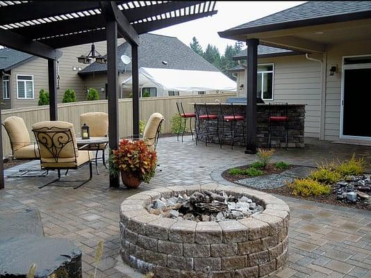 A great outdoor living area with outdoor kitchen, fire pit and a spacious paver patio in Vancouver Washington