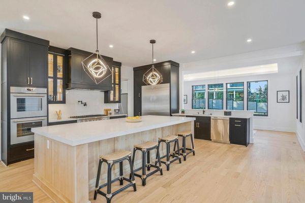 Amesbury semi-custom inset cabinets. Ebony paint in the kitchen & White Birch for the island. Calacatta Lincoln Jumbo Quartz countertops