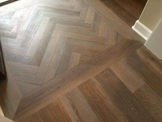 PROVENZA CASTLE GRAY INSTALLED AT ENTRY WAY, CUT AND ROUTED INTO NARROWER PLANKS AND INSTALLED IN HERRINGBONE PATTERN