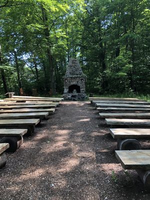 Outdoor wedding venue seating.   To the left is a brook and wildflowers.