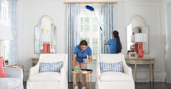 Maid Brigade team using microfiber to clean a living room.