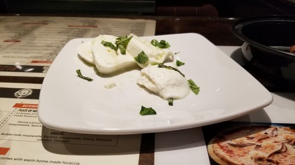 A complimentary dish of buffalo mozzarella with fresh basil