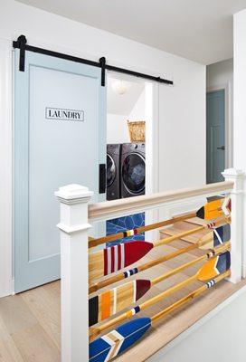 Custom oar handrail and a barn door leading into the laundry room