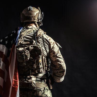 Soldier holding machine gun with national flag