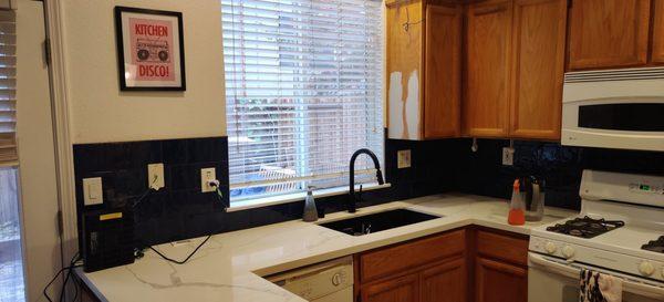 New quartz countertops, sink and tile backsplash.