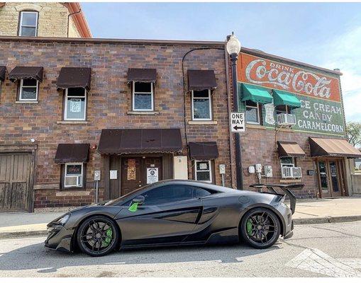 McLaren wrapped in a Satin Dark Grey (Nero) with green calipers and accents.