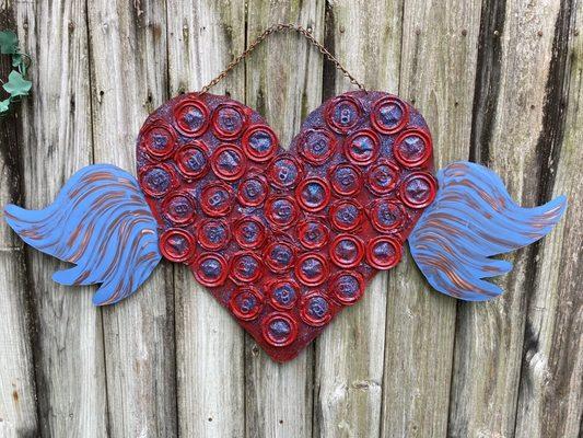 Beautiful red heart with blue & copper wings. Used sheet metal with smashed drink cans, paint & glitter!