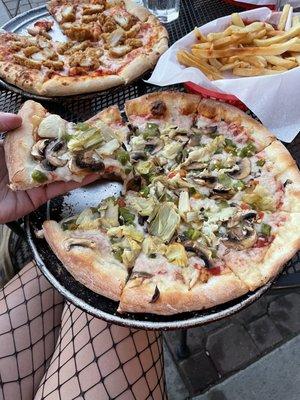 Pizza with vegan cheese, artichokes, green chilis, and mushrooms