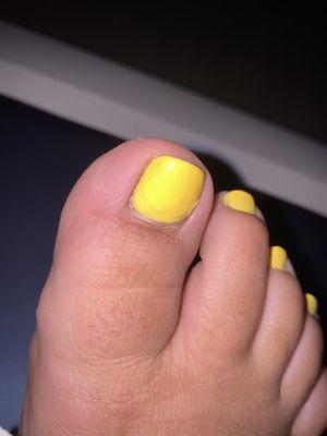 Pedicure missing cuticle work and uneven top coat application.