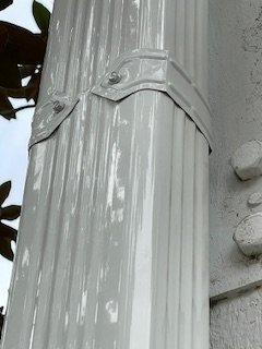 Downspout is pure white, the shadows from the tree make it look darker.