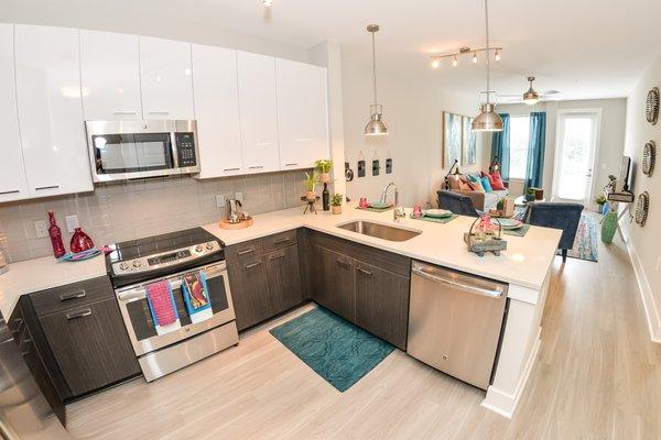 Modern kitchen w/ 2 toned cabinets, quartz countertops, and stainless steel GE appliances