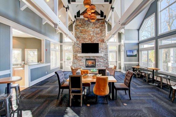 Clubhouse with high ceilings, fireplace, dining seating, TV, and kitchen.