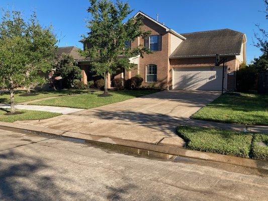 Residential hardscape service: Brush scrubbed brick entry, sidewalks, driveway, curbs & street gutter.