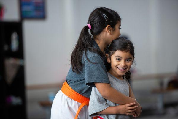 We love when families train together.  Here two sisters work on a self-defense technique.