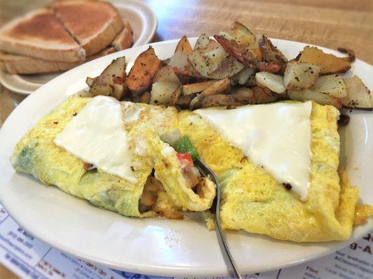 Veggie Omelette with mushroom, onions, green peppers, tomato and Swiss cheese, served with home fries and toast.