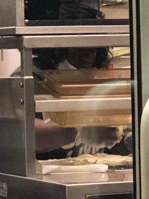 Employee making a wrap with no mask breathing all over the wrap