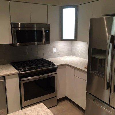 Modern kitchen remodel with glass tile backsplash.