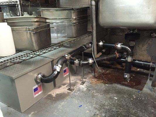 Commercial triple pot sink installation with sump pump and dual grease traps.