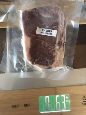 Actual packaging and weight of a cut of meat. The 0 is pounds and the right side number is ounces. A pound is 16 ounces.