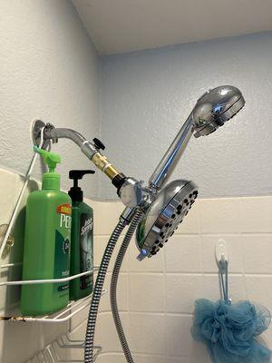 With new extension. The shower caddy no longer interferes with adjusting the main shower head assembly downward.